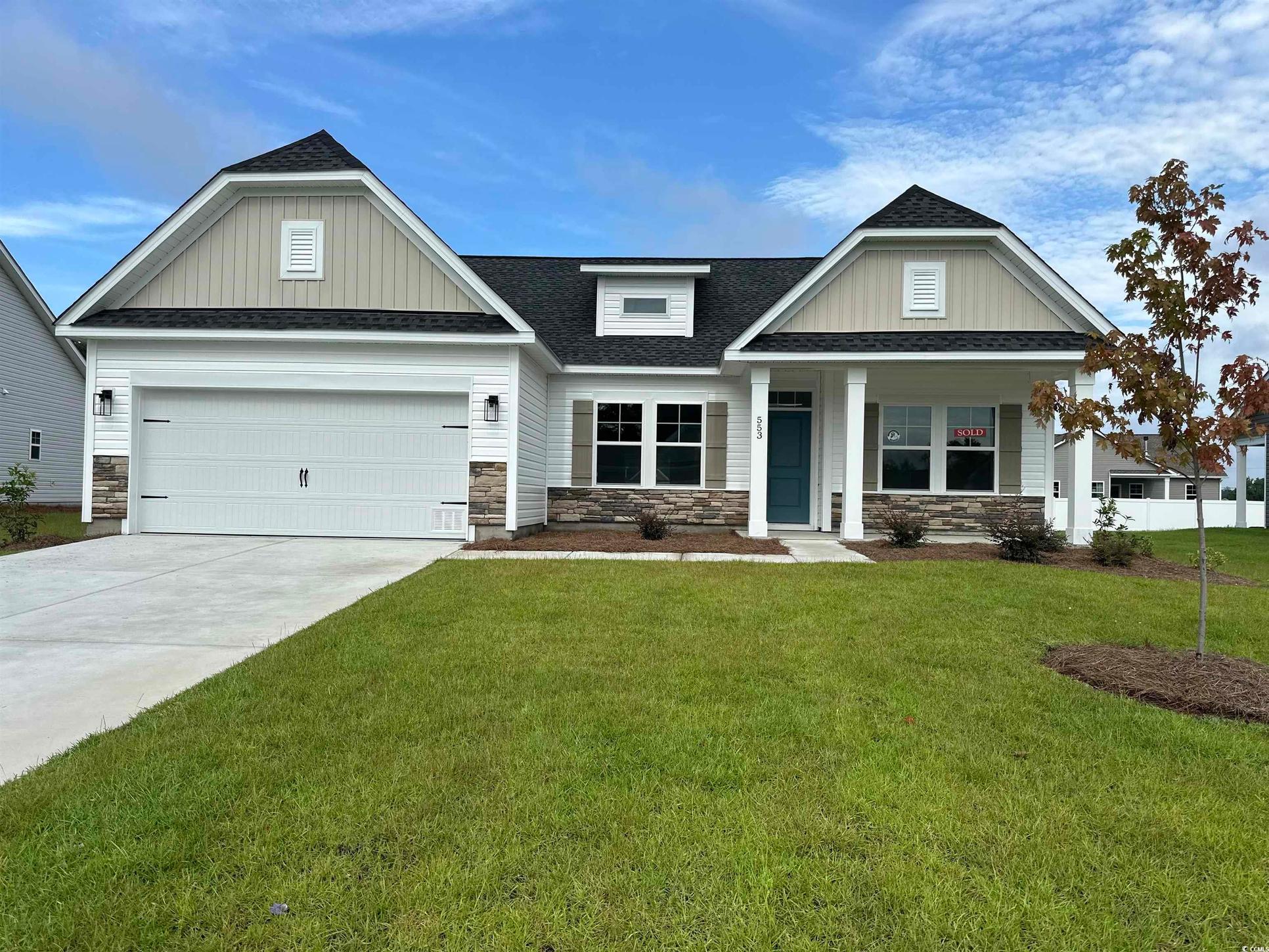 Exterior:Craftsman-style home featuring stone siding, a shingled roof, concrete driveway, and a garage