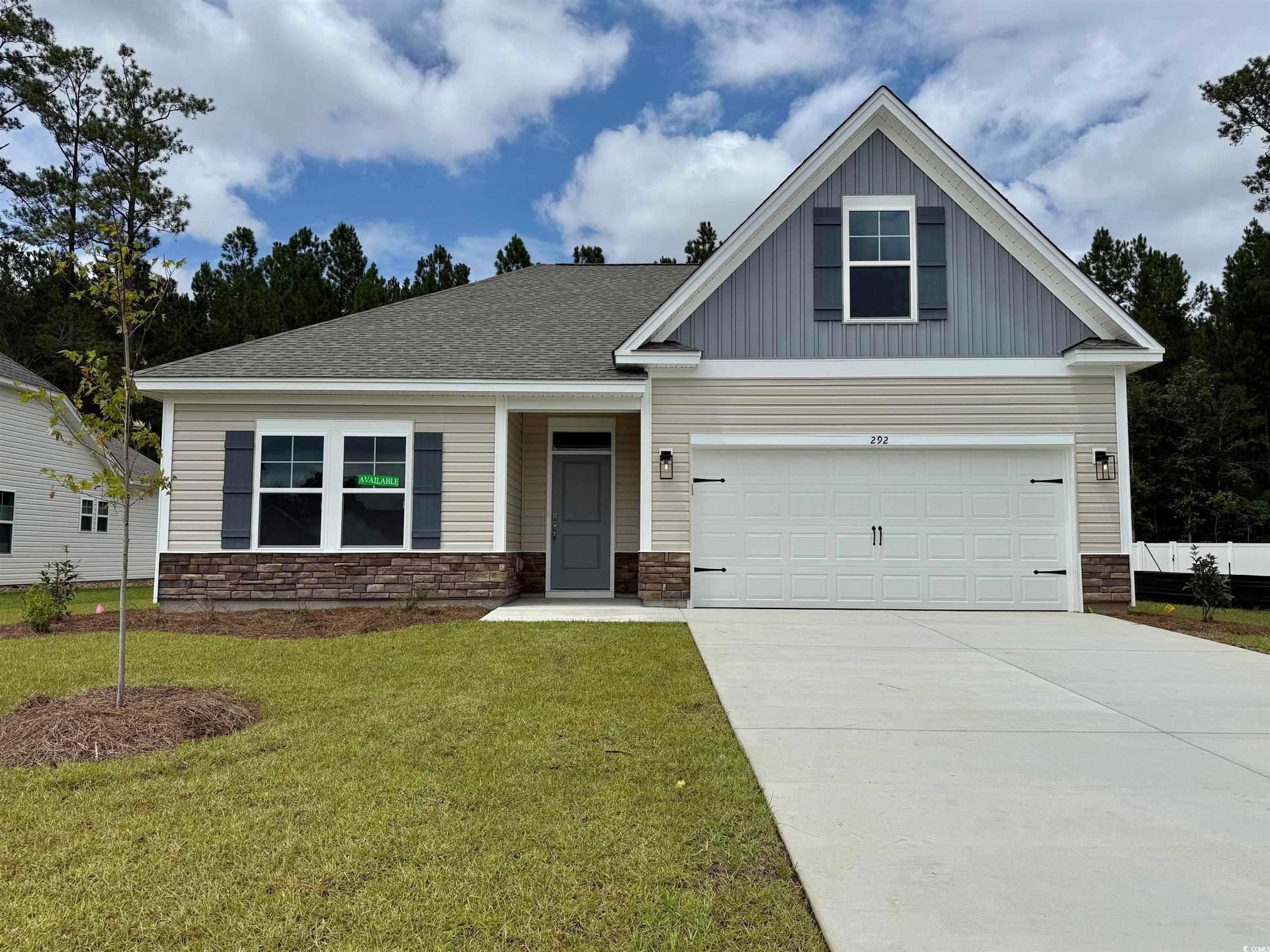 Exterior:View of front of home with stone siding, board and batten siding, and concrete driveway
