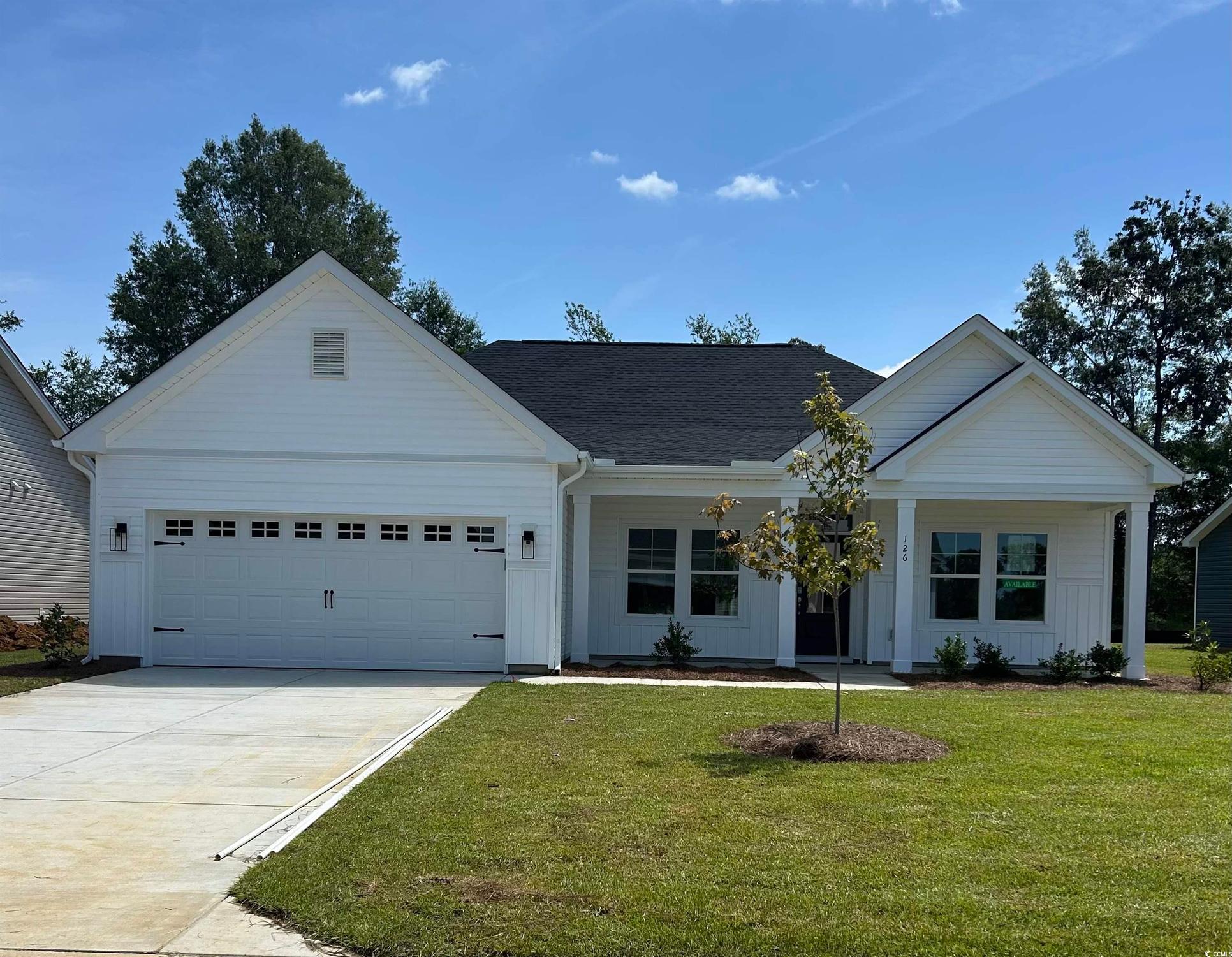 Exterior:View of front of home with board and batten siding, concrete driveway, a front yard, a garage, and