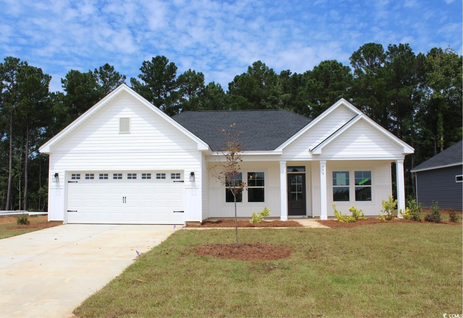 Exterior:Ranch-style house featuring a porch, a front yard, concrete driveway, an attached garage, and a shi