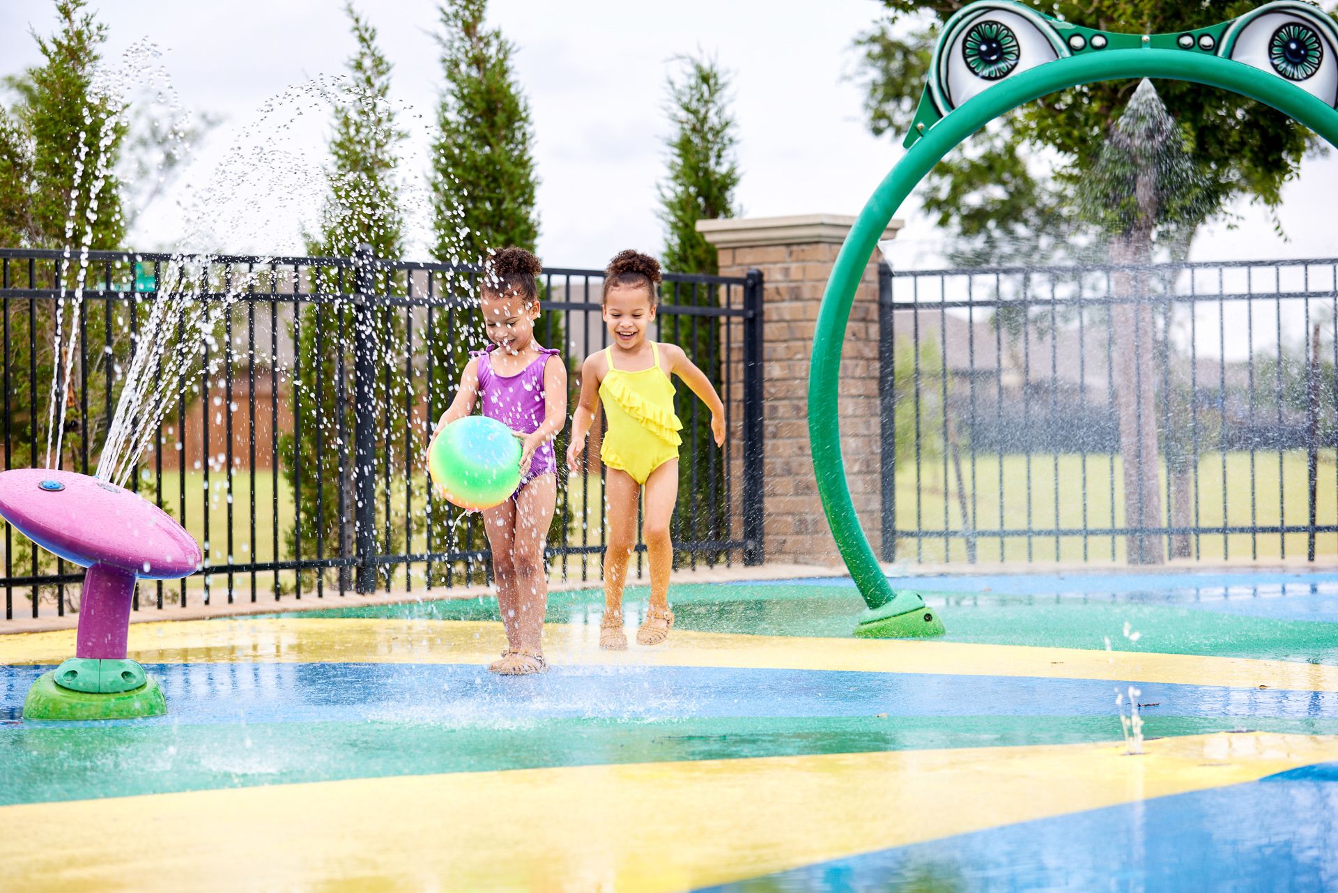 Girls playing at splash pad in Valencia - new homes in Edmond, OK