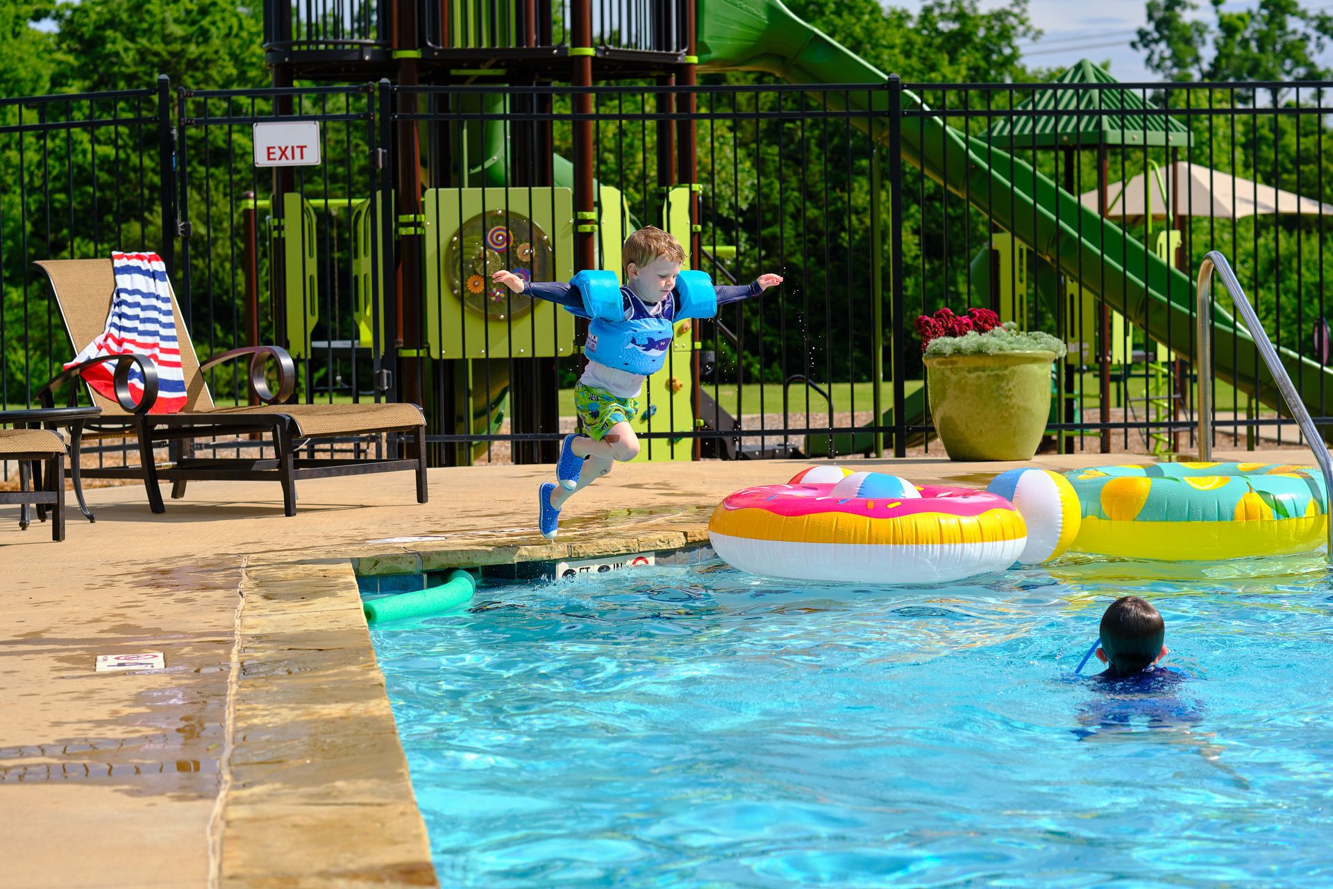 Child jumping into pool in Little River Trails - new homes in Norman, OK