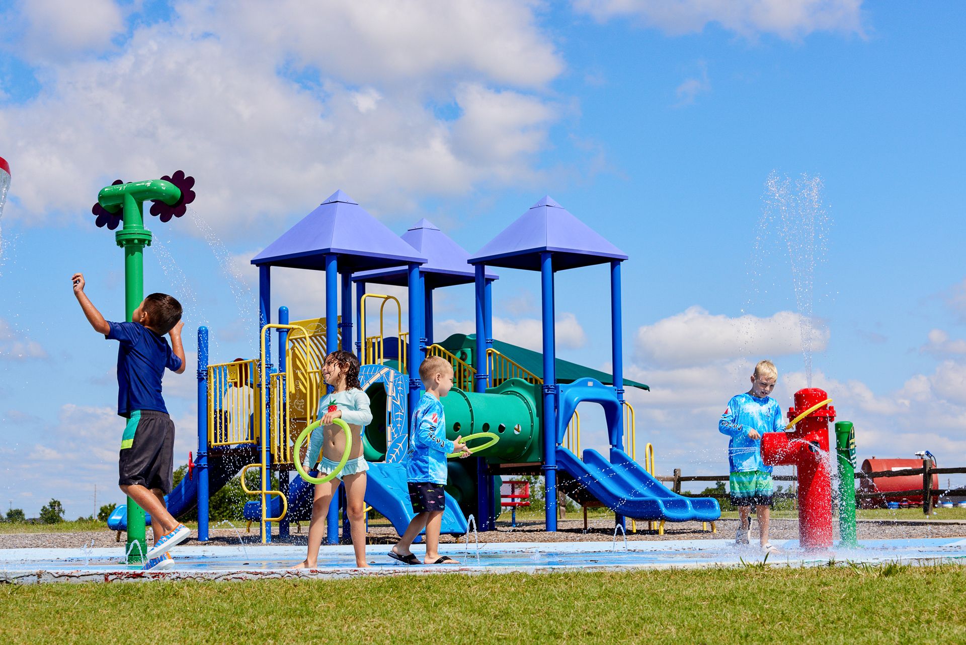 Children at the splashpad and playground in Featherstone - new homes in Moore, OK:Splash pad and playground