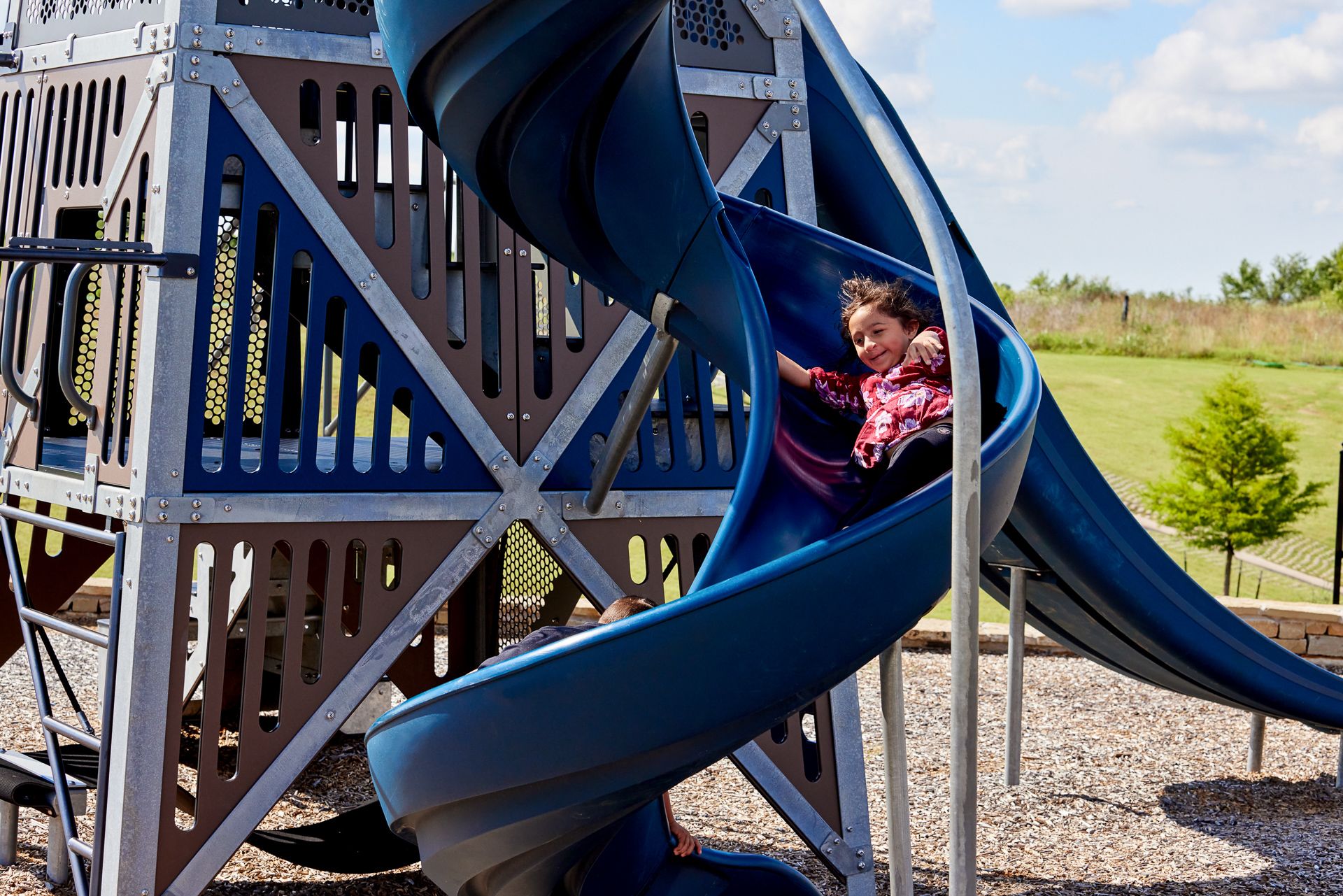 Girl sliding on playground in Native Plains - new homes in Moore, OK:Playground at Native Plains