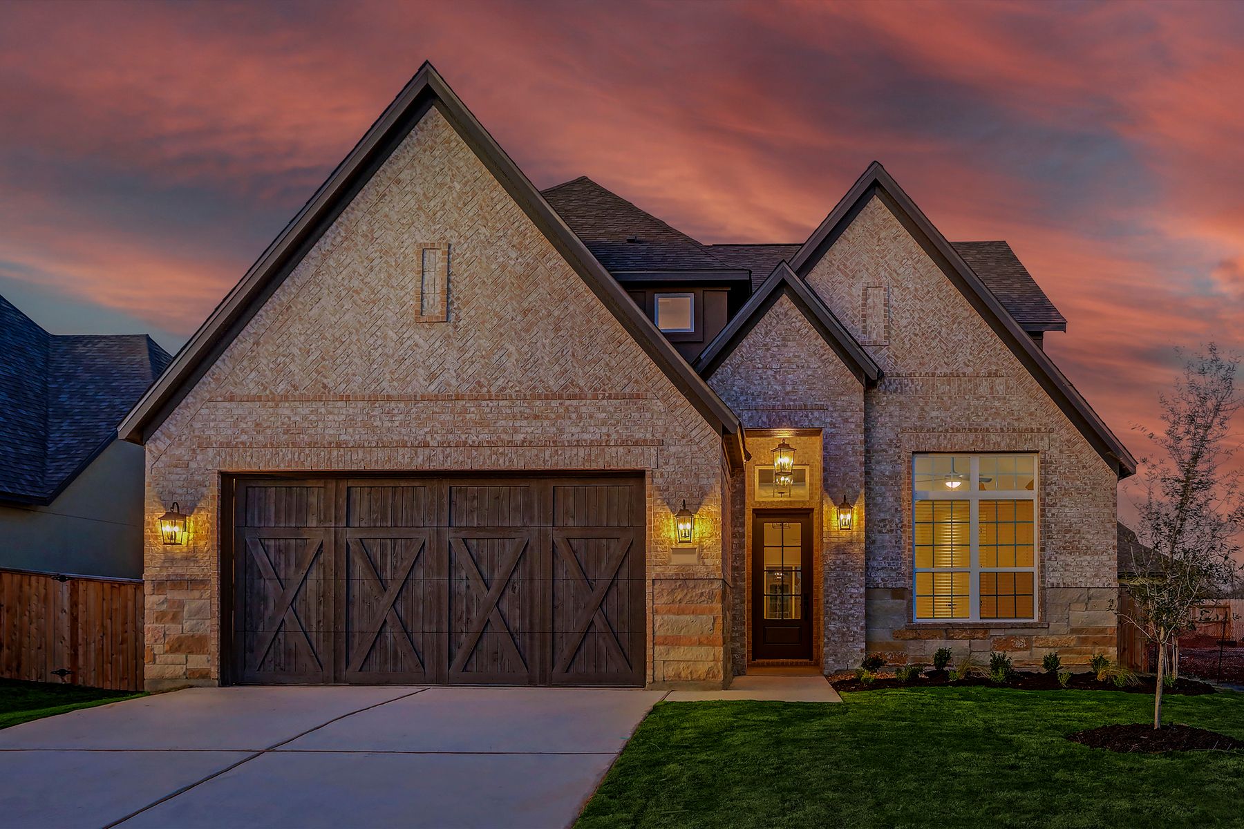 Exterior of the Welch with designer light fixtures and a two-car garage.:Terrata Homes at ShadowGlen