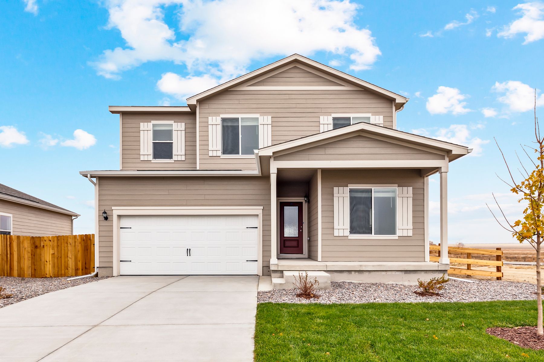 Exterior of the Harvard with a 3/4 lite front door and two-car garage.:LGI Homes at Cottonwood Greens