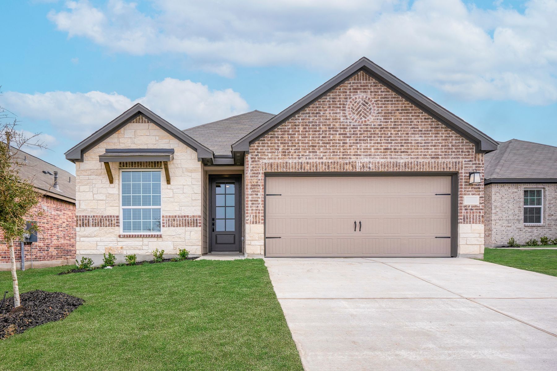 Exterior of the Fannin with stone and brick exteriors and a two-car garage.:LGI Homes at Hightop Ridge