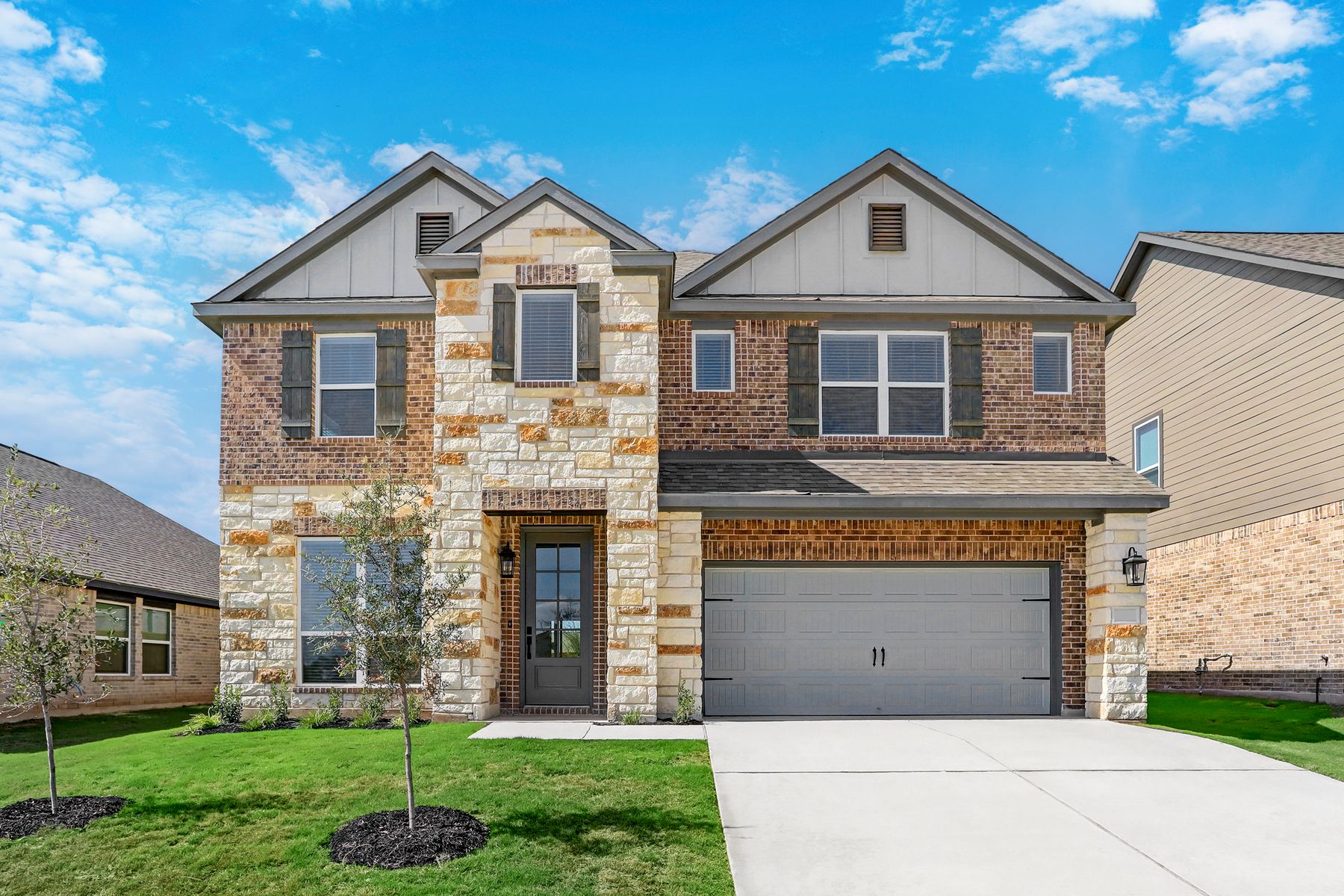 Exterior of the Sterling plan with stone and brick finishes.:Terrata Homes at Blanco Vista