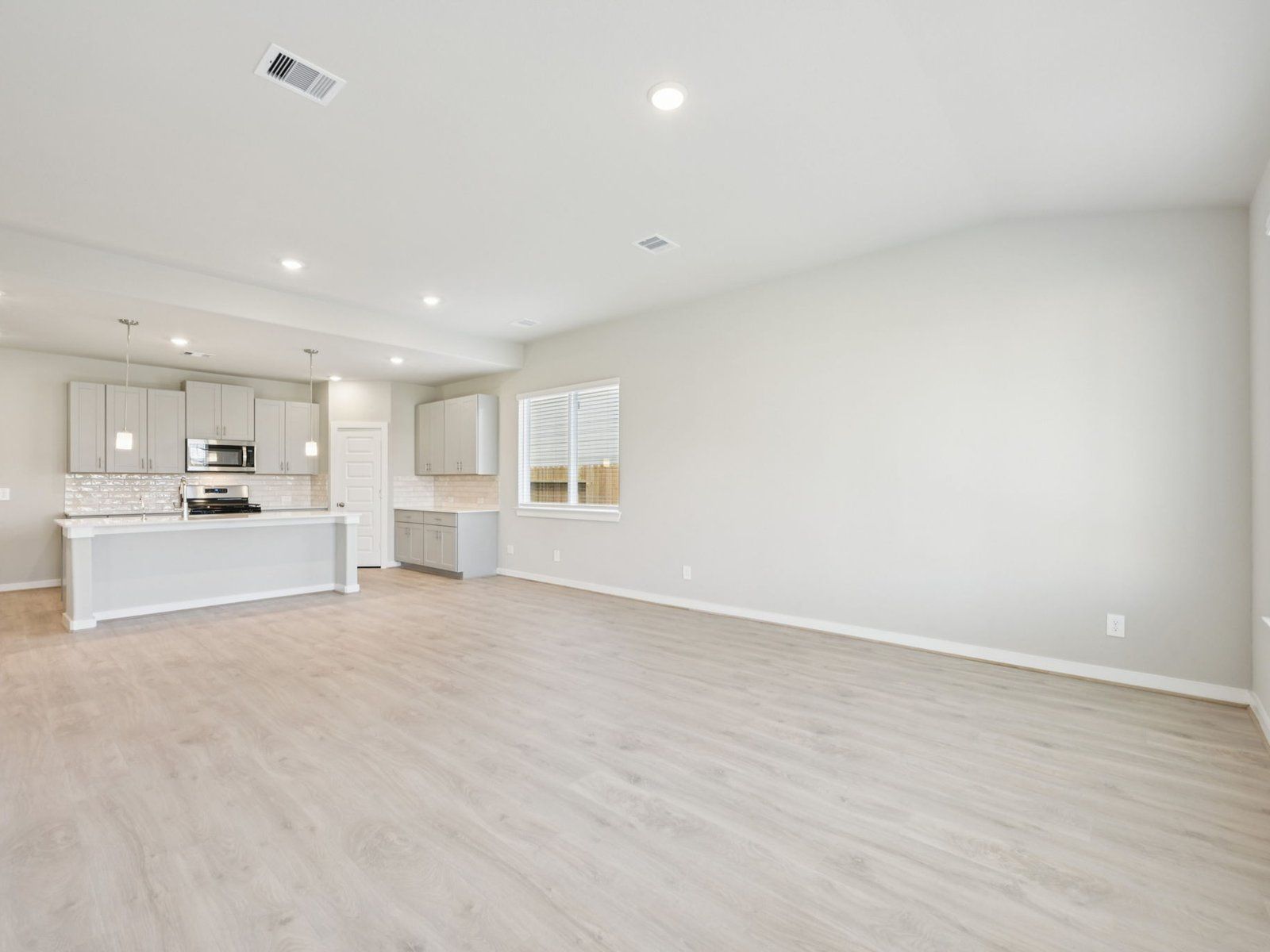 The Texoma floorplan in Glendale Lakes of Rosharon, TX.:Kitchen-Living-Dining