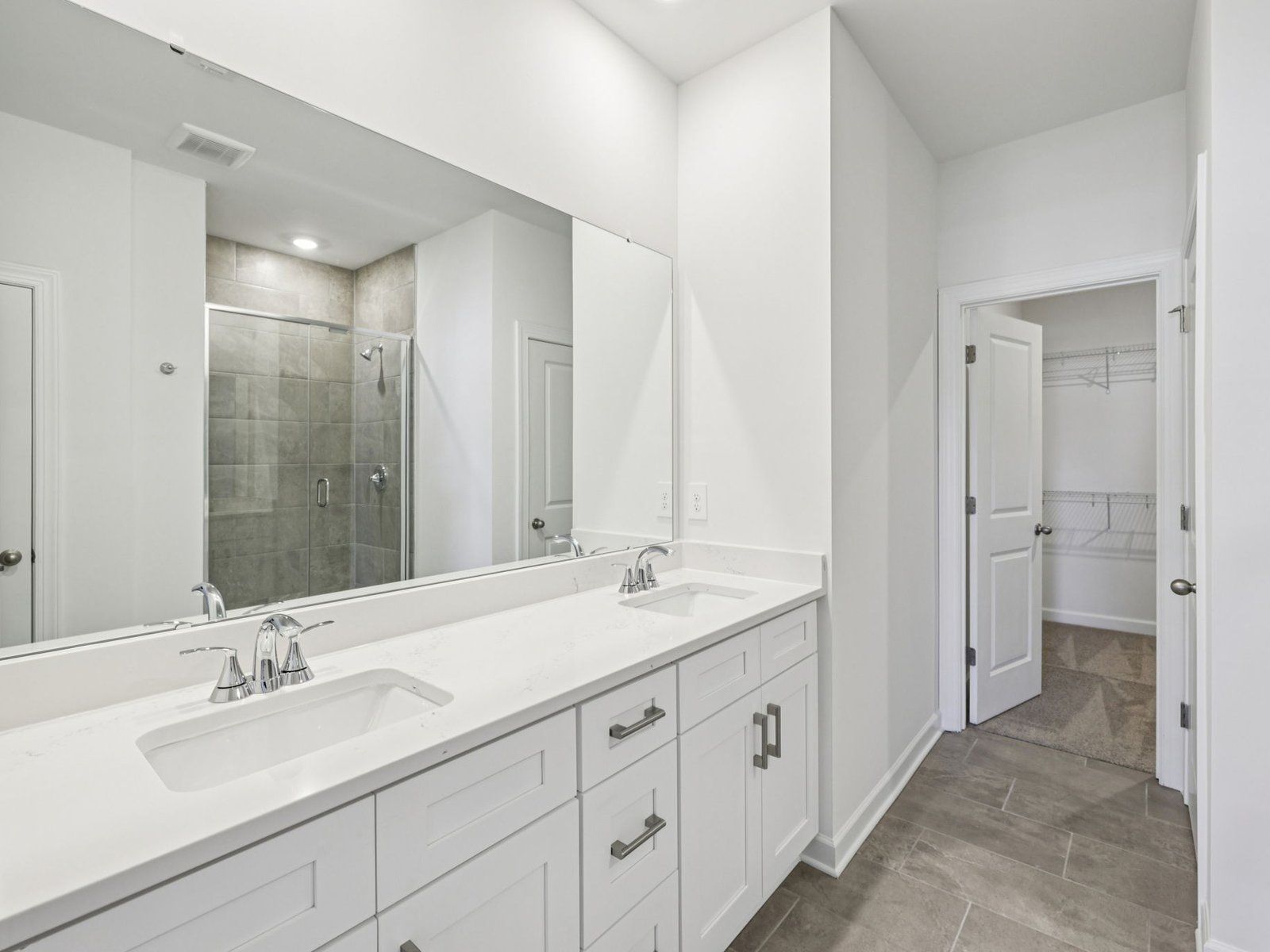 Primary Bathroom:The primary bathroom boasts a dual-sink vanity and modern walk-in shower.