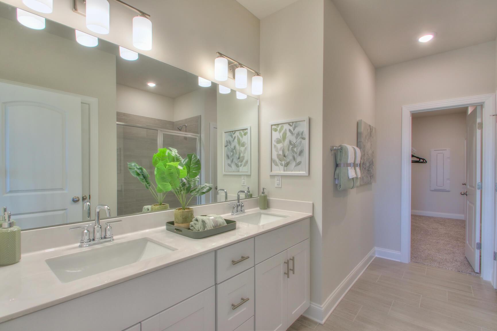 The primary bathroom offers dual sinks and a walk-in closet.:The primary bathroom offers dual sinks and a walk-in closet.