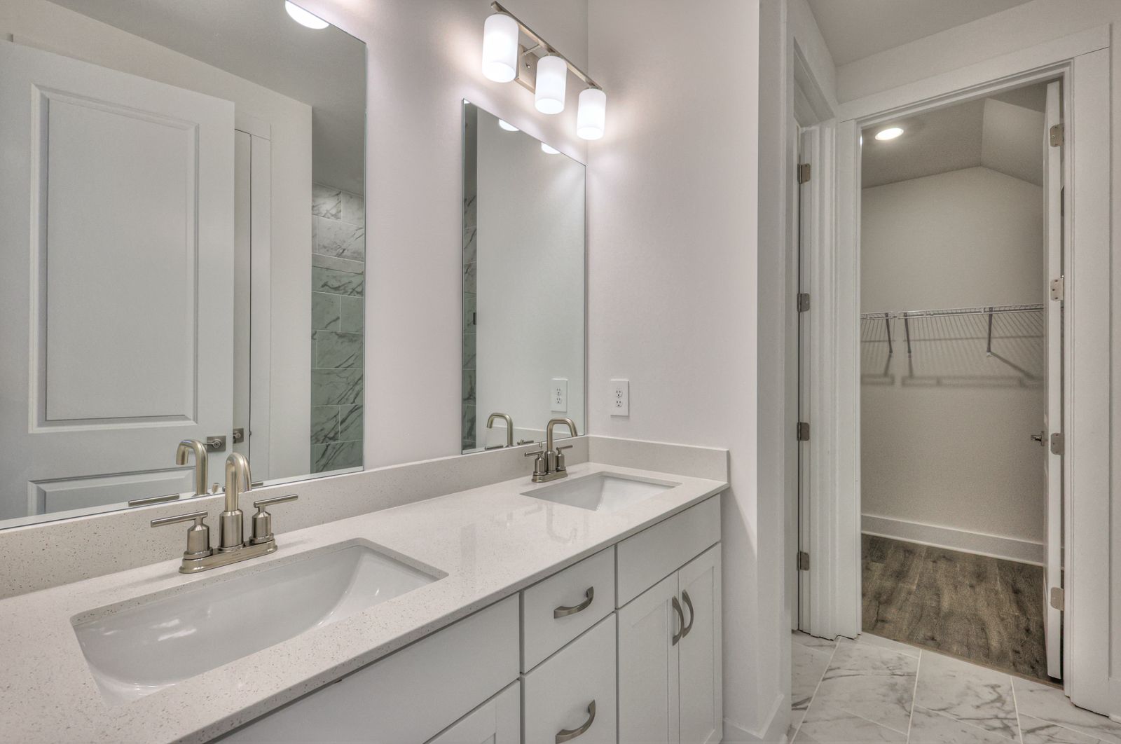 Primary Suite Bathroom:The primary bathroom offers dual vanity sinks and a walk-in closet.