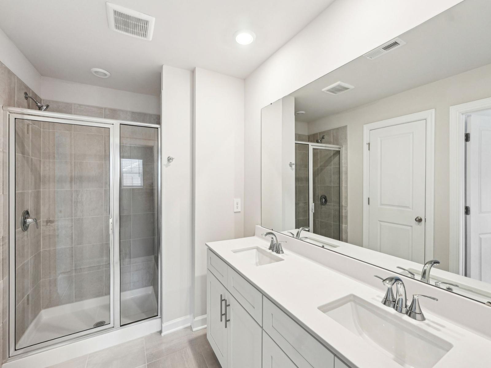 Primary Bathroom:The double-sink vanity and walk-in shower turns this primary bathroom into a spa.