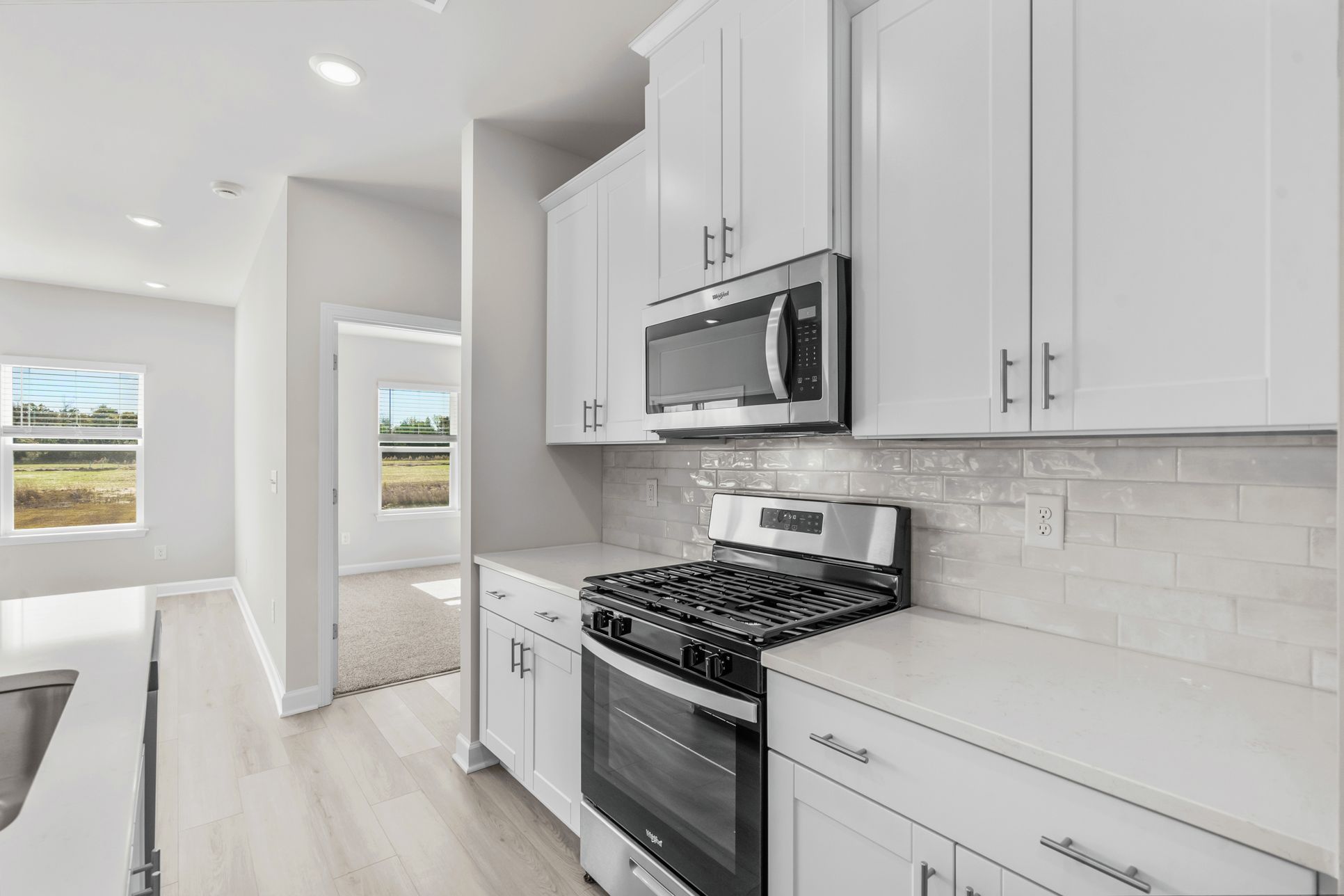 The first floor primary suite is located off of the kitchen.:The first floor primary suite is located off of the kitchen.