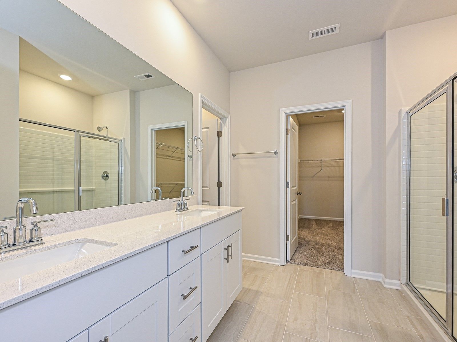 Primary Bathroom:The primary bathroom boasts a dual-sink vanity and modern walk-in shower.