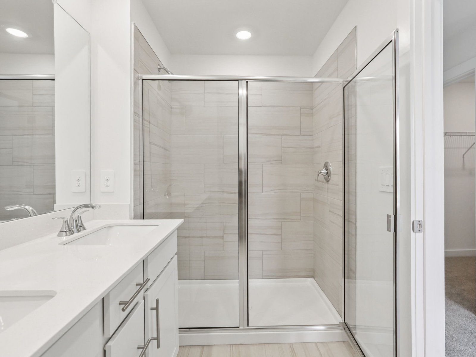 The primary bathroom offers dual vanity sinks and a walk-in shower.:Primary Bathroom