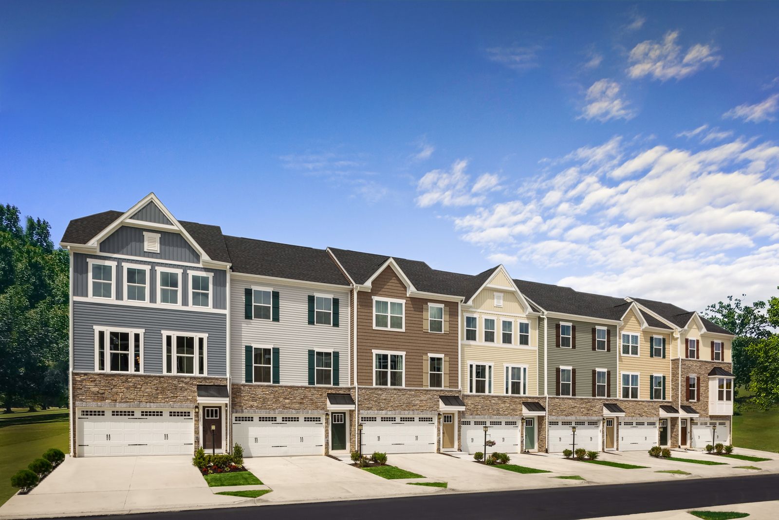 Craftsman style three level two-car garage townhomes with partial stone fronts and backyards