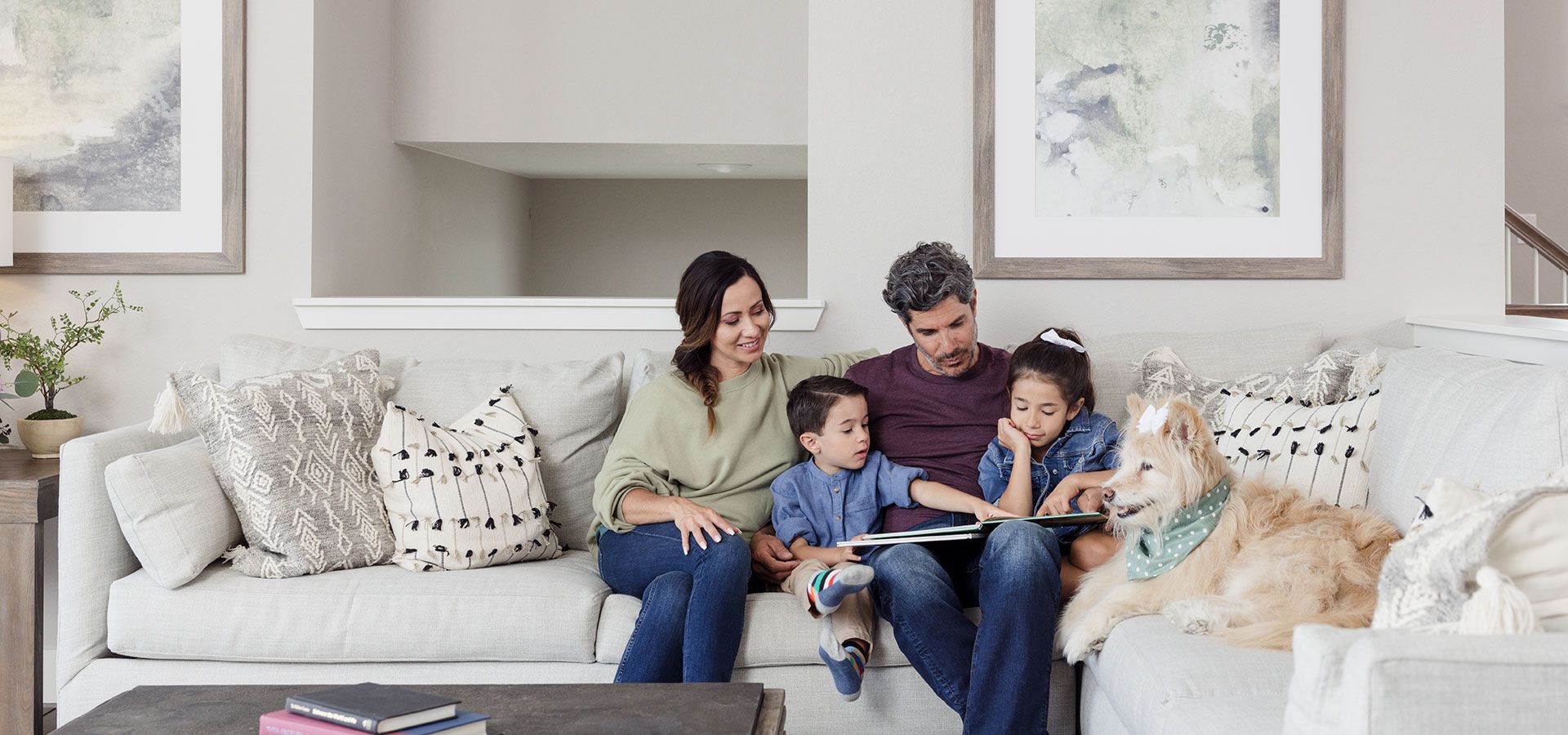 Oquirrh Mountain Ranch Hero:Image of a family on a couch representing a home in Oquirrh Mountain Ranch built by Oakwood Homes.