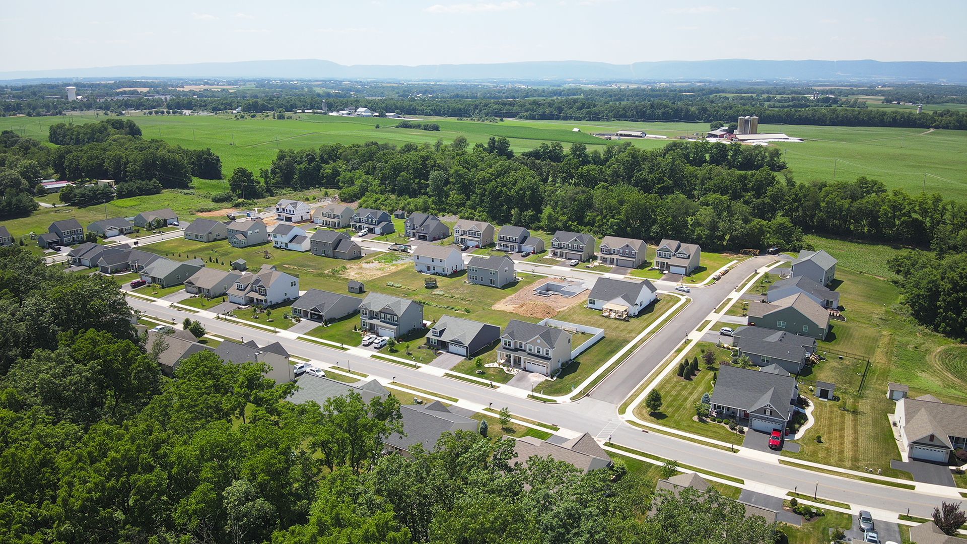 Deerfield single family homes community - surrounded by trees and mountains in the distance