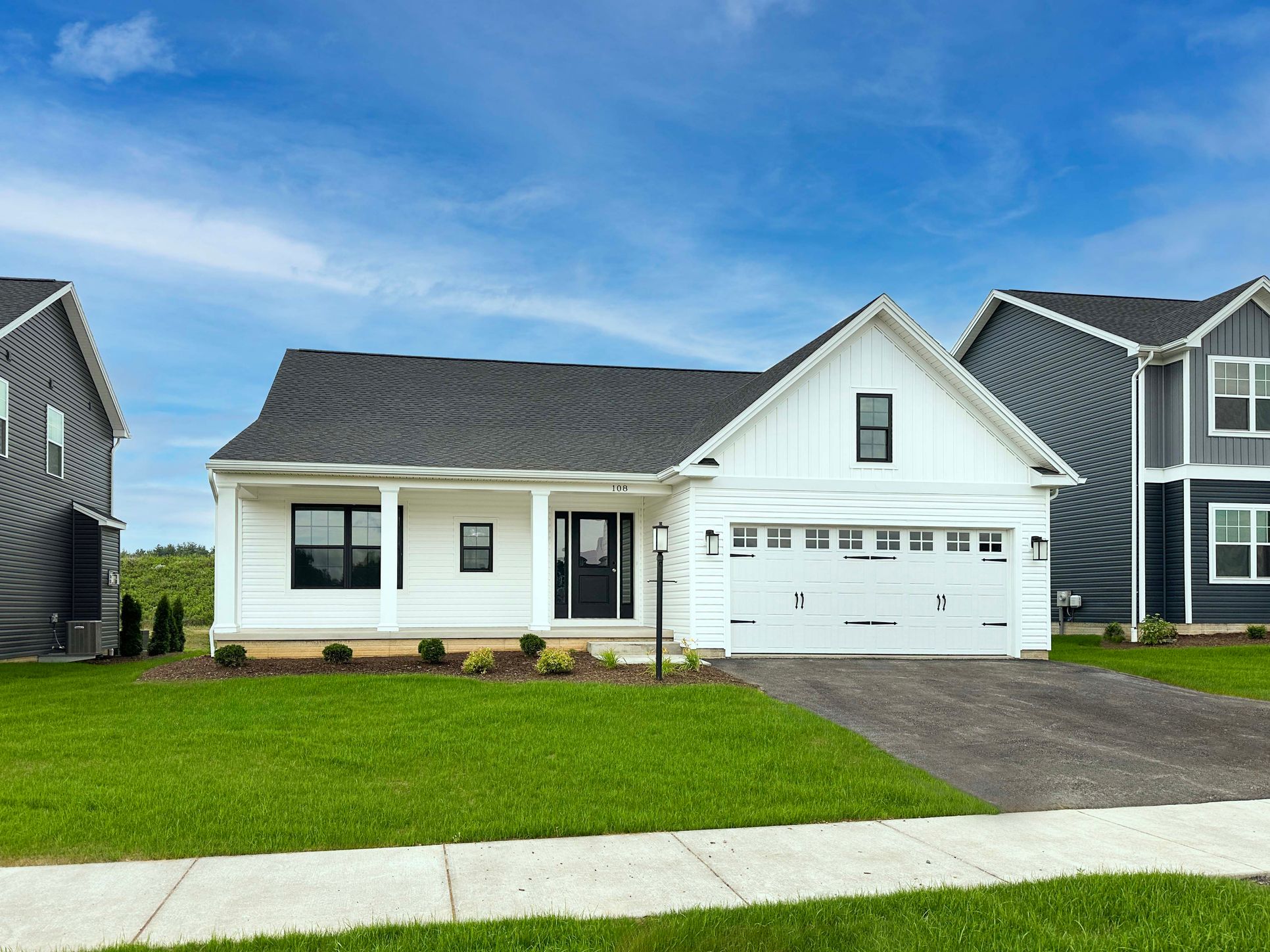 Aspen - Front exterior - single story ranch with front porch, 2 car front entry attached garage, and vinyl siding.