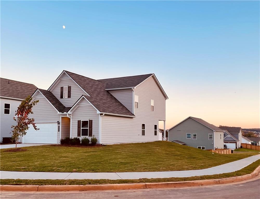 Exterior:Traditional-style house featuring a garage, a yard, a shingled roof, and driveway
