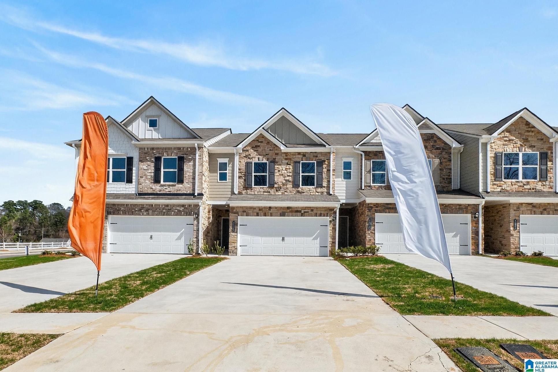 Exterior:Craftsman inspired home with an attached garage, driveway, stone siding, and board and batten sidin