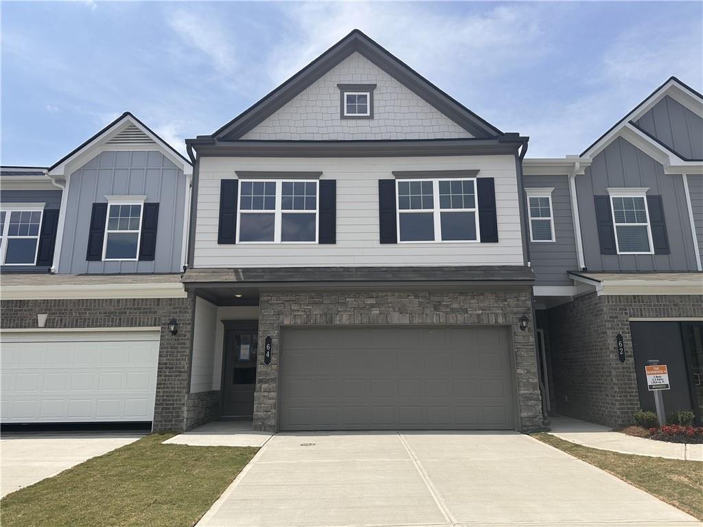 Exterior:View of front facade featuring an attached garage, concrete driveway, board and batten siding, and