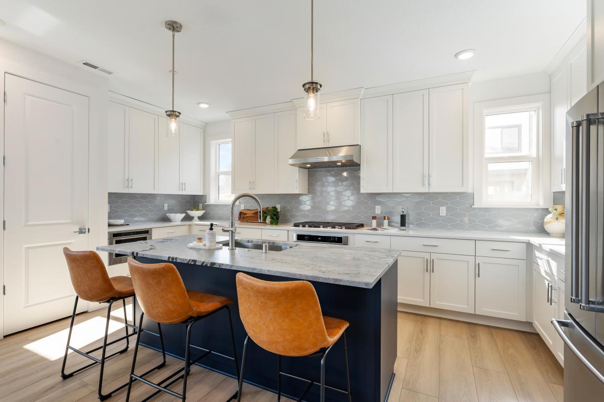 Elevation Image:Open-concept kitchen with large central island, sleek cabinetry, and ample storage
