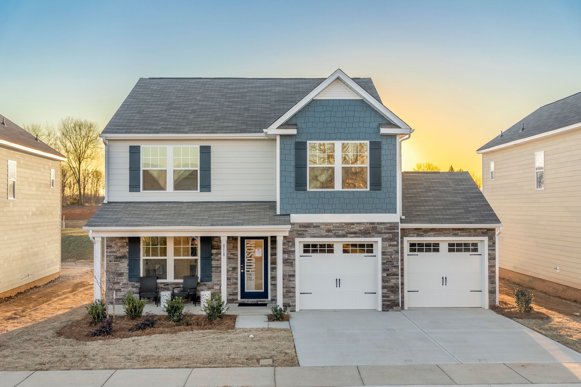 Exterior:A large blue and white house with two garages and a porch.